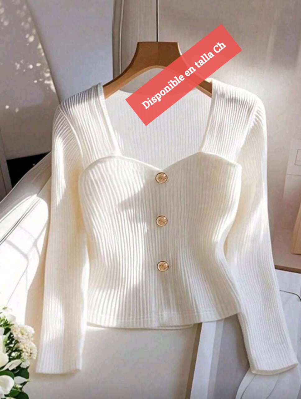 Color: Blanco / marfil  Talla: Ch (S / chica)  Diseño:  Tejido acanalado en todo el cuerpo  Corte tipo “corset suave” en la parte superior  Botones frontales metálicos dorados  Cuello cuadrado amplio  Mangas: Largas  Estilo: Femenino, elegante y mode