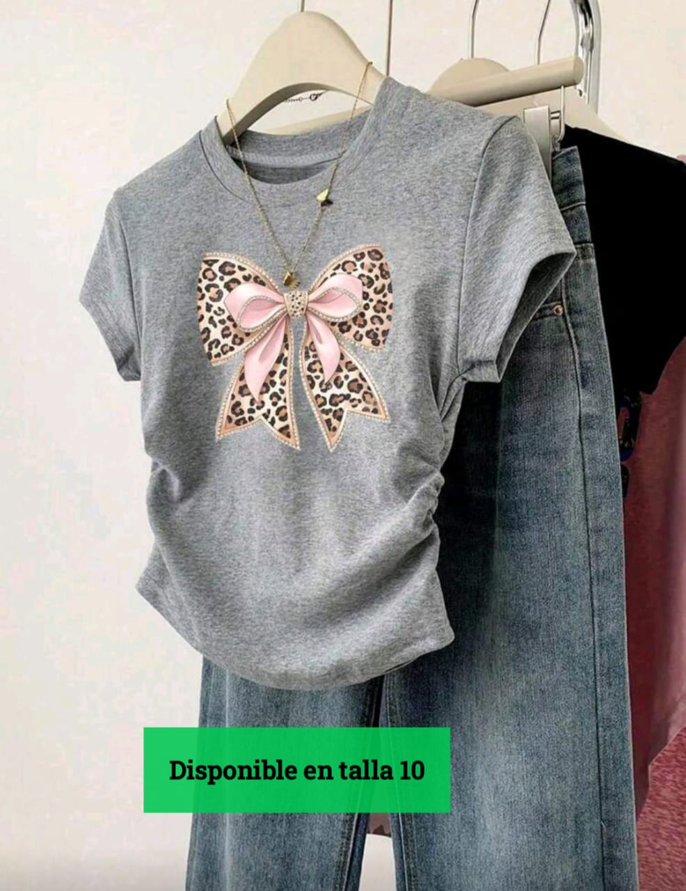Descripción de la playera  Tipo: Playera para niña.  Talla disponible: 10  Color: Gris jaspe.  Diseño:  Estampado grande de moño rosa con detalles animal print (leopardo).  Mangas cortas.  Corte clásico y cómodo.  Estil